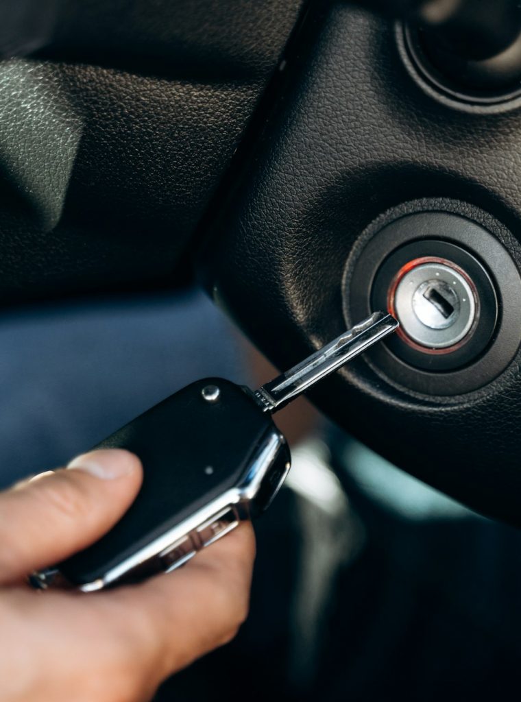 Selective focus of the male hand winds up the car ignition key